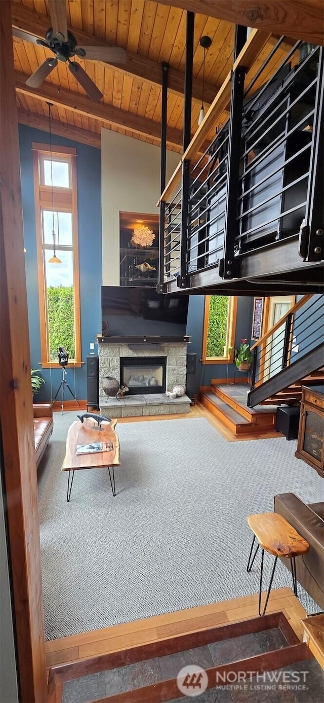 8145 Chehalis Rd, Blaine, WA 98230 - living area featuring wooden ceiling with exposed beams, a fireplace with raised hearth, and ceiling fan