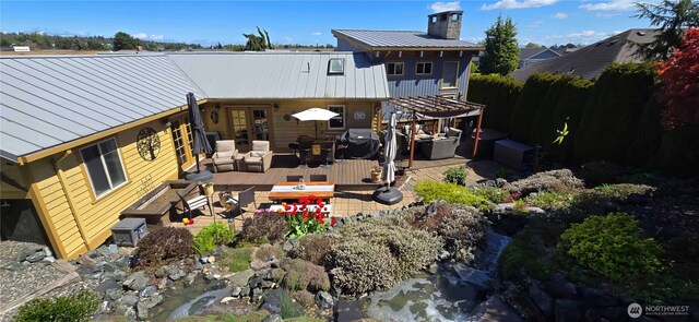 8145 Chehalis Rd, Blaine, WA 98230 - rear view of house featuring a chimney, metal roof, an outdoor hangout area, and a deck