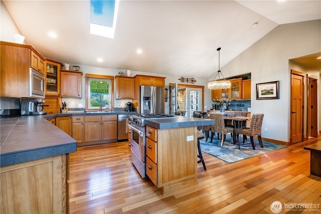 8145 Chehalis Rd, Blaine, WA 98230 - kitchen with appliances with stainless steel finishes, dark countertops, a breakfast bar, a center island, and light wood-style floors