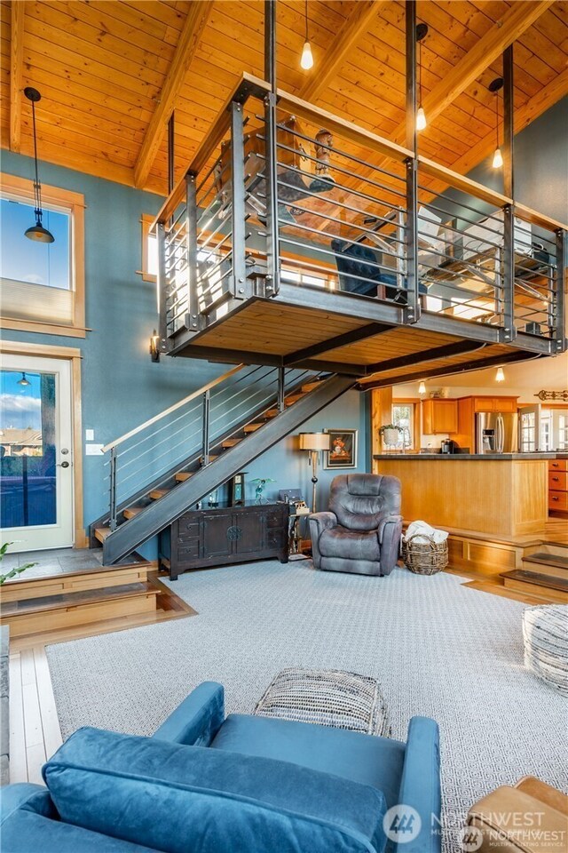 8145 Chehalis Rd, Blaine, WA 98230 - living room with stairway, high vaulted ceiling, wood ceiling with exposed beams, and hardwood / wood-style floors