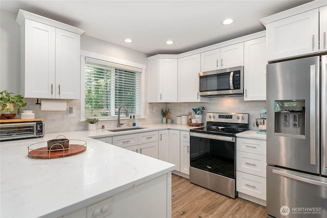 8367 Dolphin Way, Maple Falls, WA 98266 - kitchen with stainless steel appliances, a sink, white cabinetry, backsplash, and recessed lighting