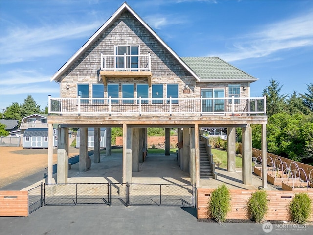 144 Sand Dune Ave SW, Ocean Shores, WA 98569 - view of front of home featuring a carport, a gate, a balcony, and stone siding