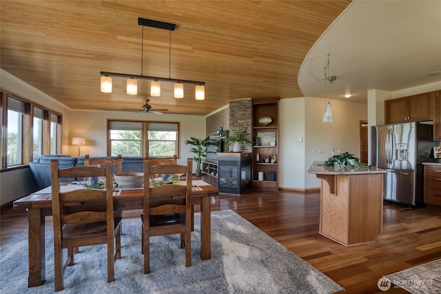 144 Sand Dune Ave SW, Ocean Shores, WA 98569 - dining area featuring wooden ceiling, dark wood-type flooring, a ceiling fan, a multi sided fireplace, and baseboards