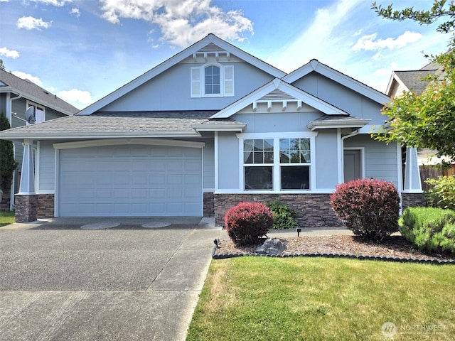 10127 Terra Valley St SE, Yelm, WA 98597 - view of front of home featuring stone siding, concrete driveway, a front yard, and a garage