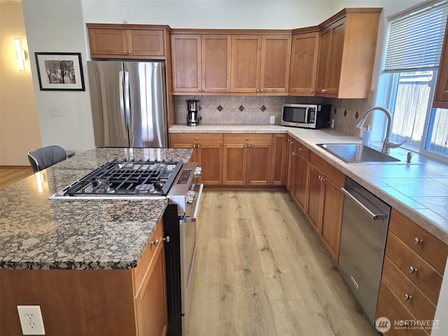 10127 Terra Valley St SE, Yelm, WA 98597 - kitchen featuring stainless steel appliances, a sink, light wood-style floors, and backsplash
