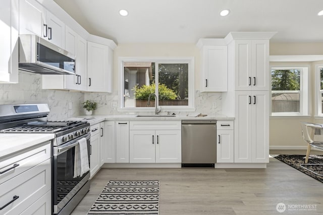 16828 Ambaum Blvd S, Burien, WA 98148 - kitchen featuring stainless steel appliances, recessed lighting, white cabinetry, backsplash, and light wood finished floors