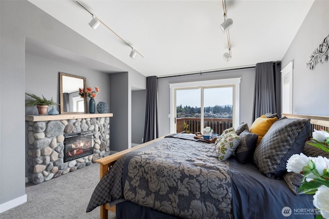 37981 Hood Canal Dr NE, Hansville, WA 98340 - bedroom featuring rail lighting, access to outside, carpet floors, a stone fireplace, and vaulted ceiling