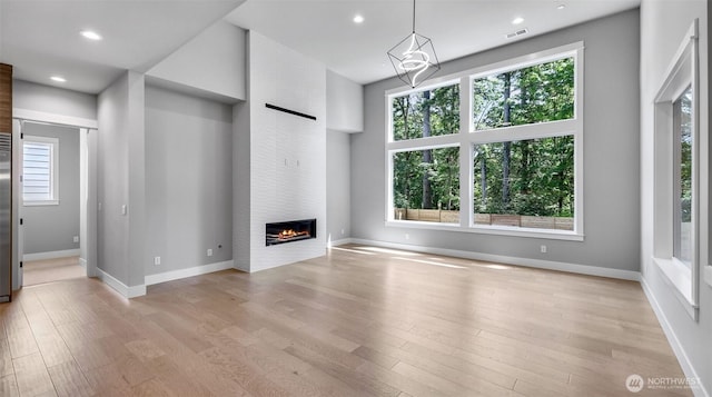 1542 213th Ct NE, Sammamish, WA 98074 - unfurnished living room with plenty of natural light, light wood finished floors, a large fireplace, and recessed lighting