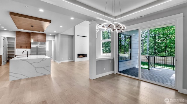 1542 213th Ct NE, Sammamish, WA 98074 - kitchen with high quality fridge, modern cabinets, a sink, a tray ceiling, and brown cabinets