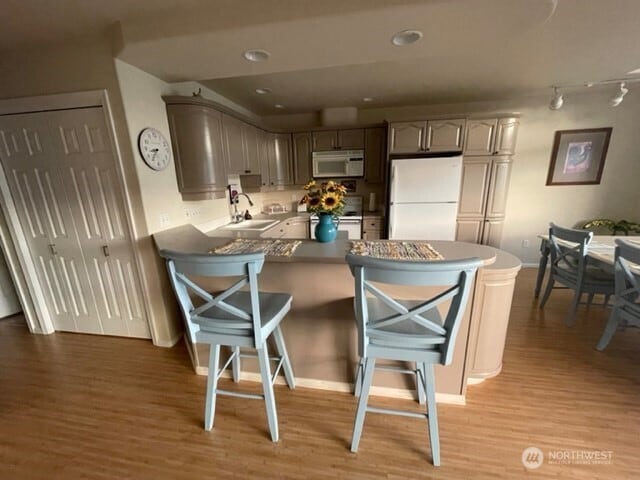 304 Sr 150 Unit 1A, Chelan, WA 98816 - kitchen with white appliances, a sink, light wood-style floors, a peninsula, and recessed lighting