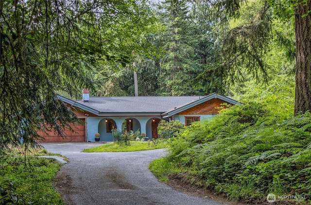 70 Cole Ave, Port Townsend, WA 98368 - ranch-style home with curved driveway, a chimney, a garage, and stucco siding