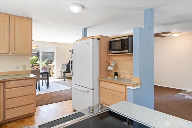 4404 Lopez St, Port Townsend, WA 98368 - kitchen featuring stainless steel microwave, freestanding refrigerator, light brown cabinetry, ceiling fan, and light countertops