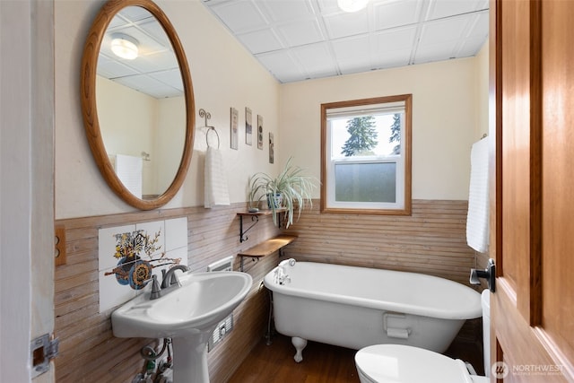 1010 Tacoma Ave, Port Orchard, WA 98366 - bathroom with a freestanding tub, wainscoting, wood finished floors, tile walls, and toilet