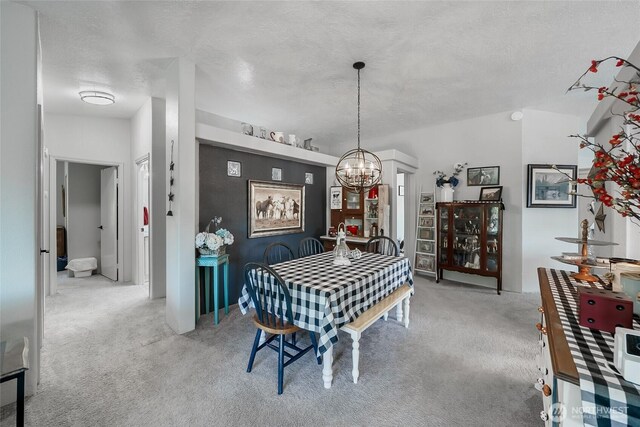 10419 Sandridge Rd, Long Beach, WA 98631 - dining room featuring a chandelier, carpet, and a textured ceiling