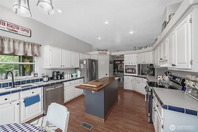 10419 Sandridge Rd, Long Beach, WA 98631 - kitchen with stainless steel appliances, white cabinets, dark wood-style flooring, a center island, and recessed lighting