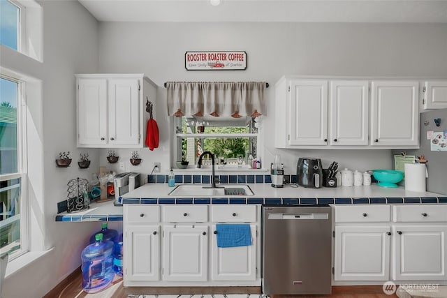 10419 Sandridge Rd, Long Beach, WA 98631 - kitchen with stainless steel dishwasher, white cabinetry, and tile countertops