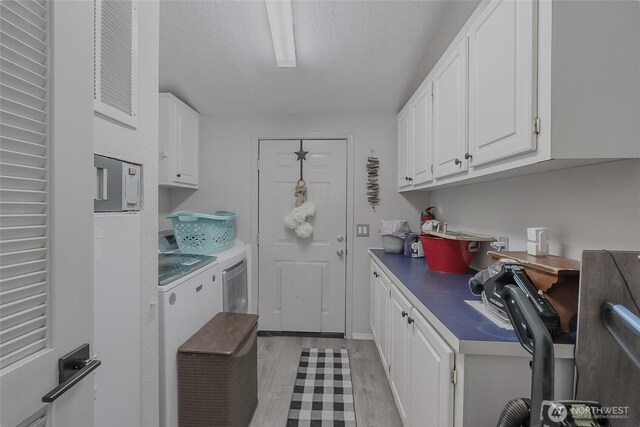 10419 Sandridge Rd, Long Beach, WA 98631 - washroom featuring washer and dryer, light wood finished floors, a desk, and a textured ceiling