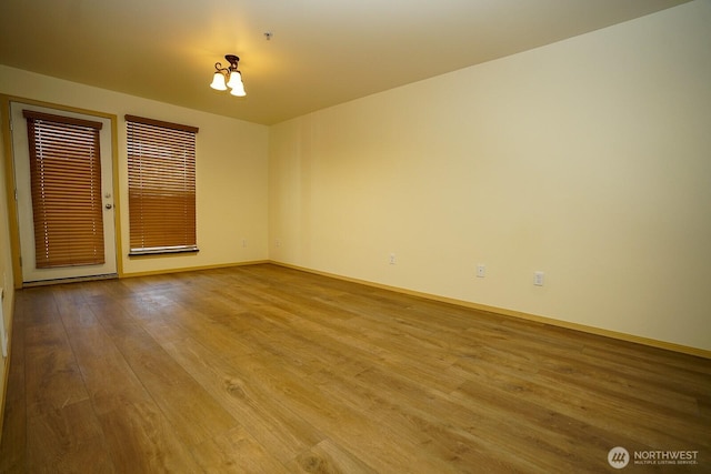 1031 N State St Unit 402, Bellingham, WA 98226 - unfurnished room featuring wood finished floors, baseboards, and a pendent fire sprinkler