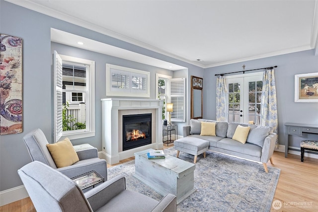 1747 Parade Grounds Ave NE, Bainbridge Island, WA 98110 - living room with french doors, ornamental molding, a glass covered fireplace, light wood-style floors, and recessed lighting
