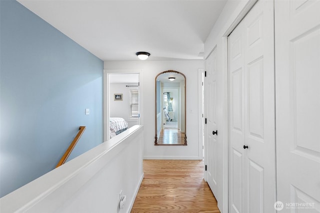 1747 Parade Grounds Ave NE, Bainbridge Island, WA 98110 - corridor featuring an upstairs landing, light wood-style flooring, and arched walkways
