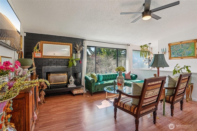 29103 46th Pl S, Auburn, WA 98001 - living room featuring a textured ceiling, ceiling fan, wood finished floors, and a brick fireplace