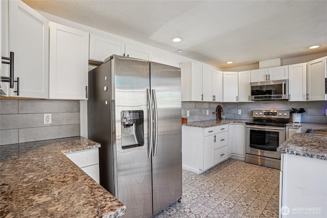29103 46th Pl S, Auburn, WA 98001 - kitchen featuring appliances with stainless steel finishes, decorative backsplash, white cabinets, dark stone countertops, and recessed lighting