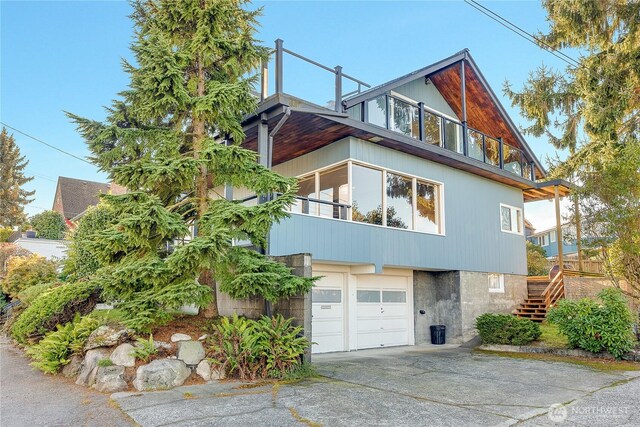 2301 37th Ave SW, Seattle, WA 98126 - view of front facade with concrete driveway, stairway, and a garage