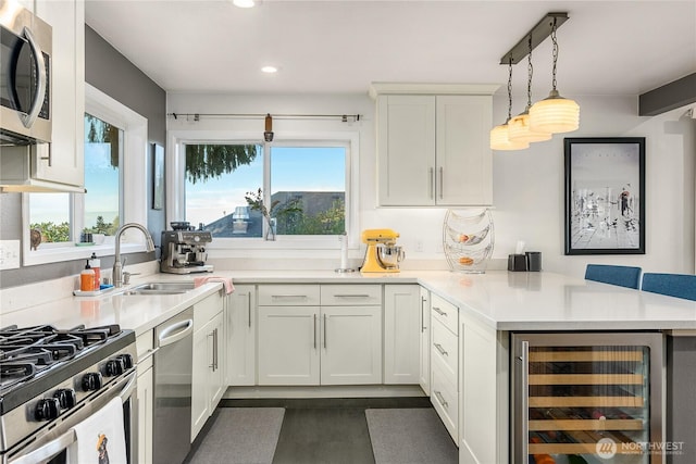 2301 37th Ave SW, Seattle, WA 98126 - kitchen with appliances with stainless steel finishes, beverage cooler, a peninsula, recessed lighting, and a sink