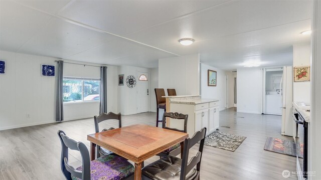 1510 Maple Ln Unit 16, Kent, WA 98030 - dining room with light wood finished floors, washer / clothes dryer, and baseboards
