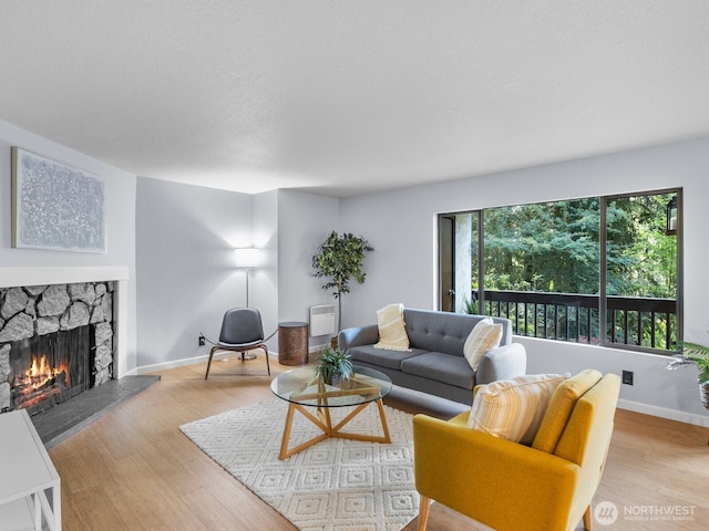 18210 15th Ave NE Unit 101, Shoreline, WA 98155 - living room featuring a fireplace, wood finished floors, and baseboards