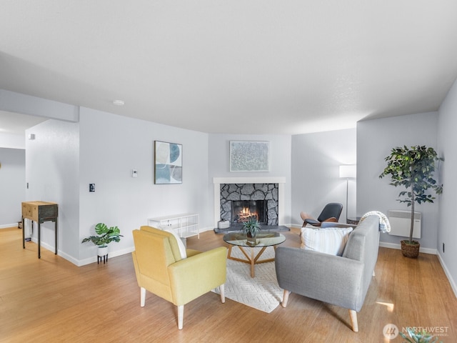 18210 15th Ave NE Unit 101, Shoreline, WA 98155 - living area with light wood-style floors, a stone fireplace, baseboards, and radiator heating unit