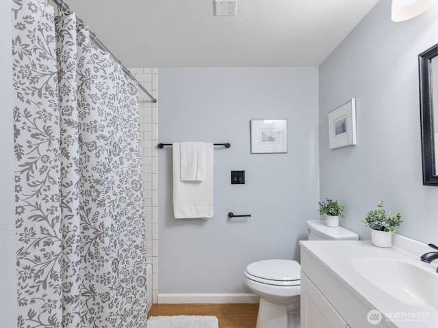 18210 15th Ave NE Unit 101, Shoreline, WA 98155 - bathroom with toilet, vanity, wood finished floors, curtained shower, and baseboards