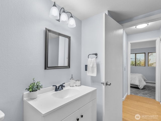 18210 15th Ave NE Unit 101, Shoreline, WA 98155 - bathroom featuring vanity, wood finished floors, connected bathroom, and baseboards