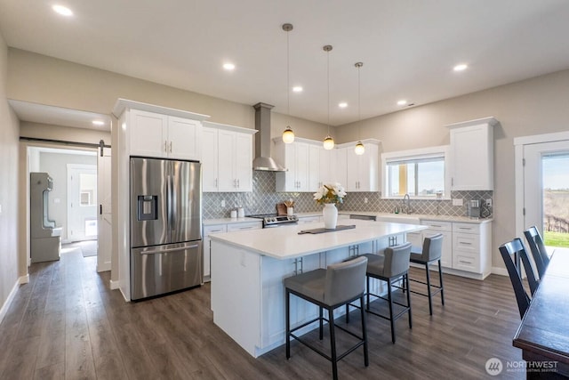 26602 N Rothrock Rd, Prosser, WA 99350 - kitchen featuring stainless steel appliances, a kitchen island, wall chimney range hood, white cabinetry, and recessed lighting