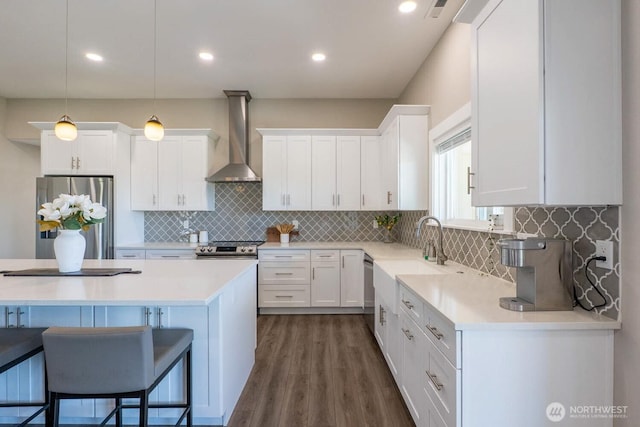 26602 N Rothrock Rd, Prosser, WA 99350 - kitchen featuring appliances with stainless steel finishes, wall chimney exhaust hood, a kitchen bar, white cabinets, and recessed lighting