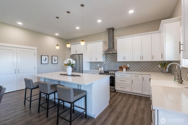 26602 N Rothrock Rd, Prosser, WA 99350 - kitchen with wall chimney exhaust hood, appliances with stainless steel finishes, a kitchen island, white cabinetry, and backsplash