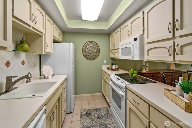 2253 Gilman Dr W Unit 207, Seattle, WA 98119 - kitchen featuring white appliances, a sink, light countertops, a tray ceiling, and tasteful backsplash
