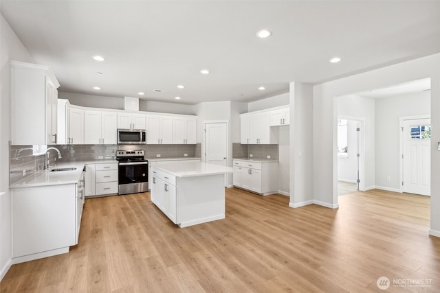 16617 8th Avenue Ct E Unit 9, Spanaway, WA 98387 - kitchen featuring stainless steel appliances, decorative backsplash, a kitchen island, light countertops, and recessed lighting