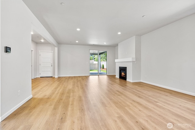 16617 8th Avenue Ct E Unit 9, Spanaway, WA 98387 - unfurnished living room featuring recessed lighting, light wood-style flooring, and a glass covered fireplace