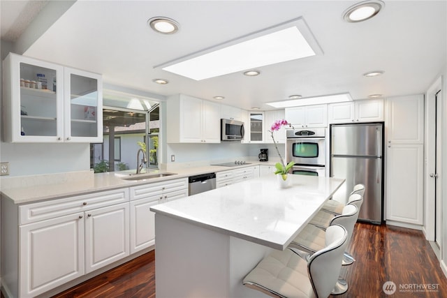 31012 151st Ave SE, Kent, WA 98042 - kitchen featuring a sink, stainless steel appliances, glass insert cabinets, a breakfast bar area, and white cabinetry