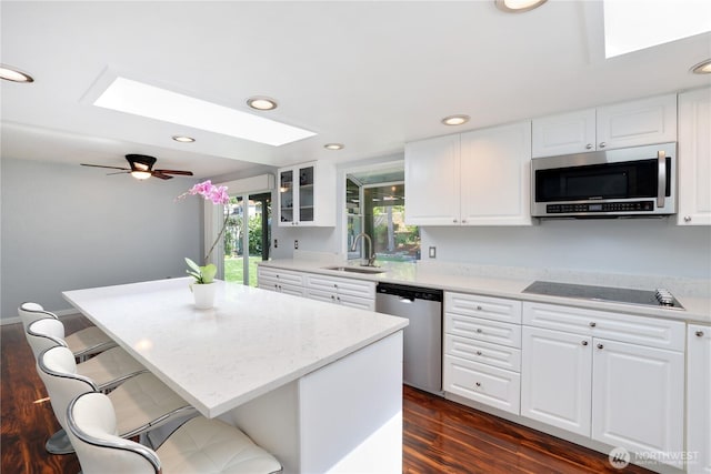 31012 151st Ave SE, Kent, WA 98042 - kitchen with a skylight, appliances with stainless steel finishes, a sink, dark wood-style floors, and a breakfast bar