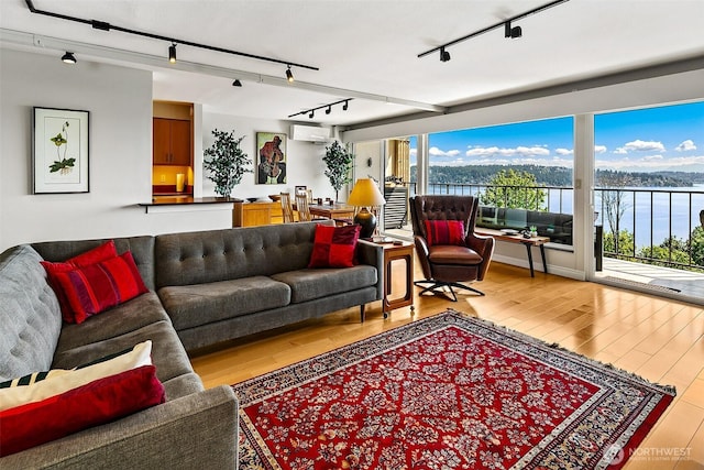 8005 Sand Point Way NE Unit A41, Seattle, WA 98115 - living room featuring rail lighting, an AC wall unit, wood finished floors, and a water view