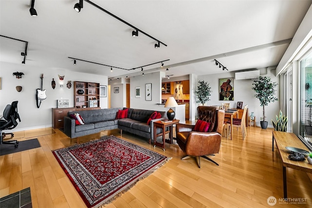 8005 Sand Point Way NE Unit A41, Seattle, WA 98115 - living area with a wall mounted air conditioner, light wood finished floors, baseboards, and rail lighting