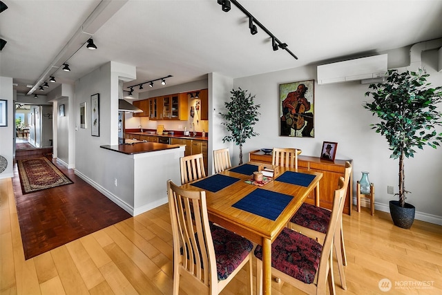 8005 Sand Point Way NE Unit A41, Seattle, WA 98115 - dining area with rail lighting, a wall mounted air conditioner, light wood-style flooring, and baseboards