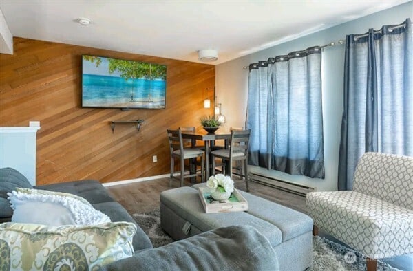 7530 Birch Bay Dr Unit 206, Blaine, WA 98230 - living room featuring plenty of natural light, wood walls, and a baseboard radiator