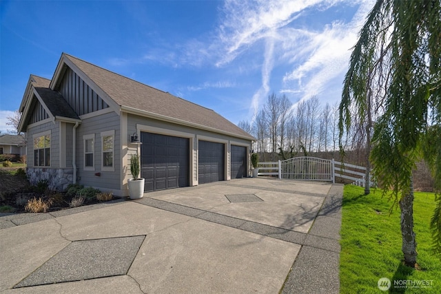 367 E Silverado Ct, Bellingham, WA 98226 - view of property exterior with board and batten siding, a gate, concrete driveway, stone siding, and roof with shingles