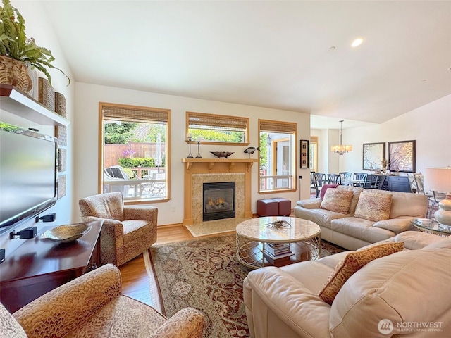 1427 N Aurora Ct, Port Angeles, WA 98363 - living area featuring vaulted ceiling, wood finished floors, a premium fireplace, and a chandelier