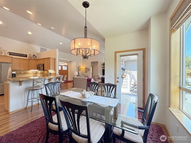 1427 N Aurora Ct, Port Angeles, WA 98363 - dining space featuring light wood finished floors, vaulted ceiling, and a chandelier
