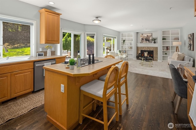 328 210th St SE, Bothell, WA 98021 - kitchen with tile counters, appliances with stainless steel finishes, a sink, dark wood finished floors, and a glass covered fireplace