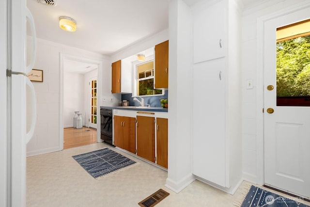 9539 Lake Shore Blvd NE, Seattle, WA 98115 - kitchen featuring freestanding refrigerator, black dishwasher, brown cabinetry, a sink, and light countertops